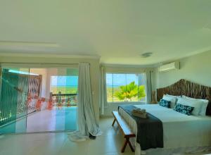 a bedroom with a bed and a view of the ocean at Chalés Alto dos Milagres in São Miguel dos Milagres +78 photos