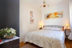 een slaapkamer met een bed en schilderijen aan de muur bij Apartments by the sea Rastici, Ciovo - 9717 in Trogir