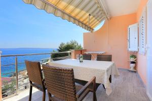 een eetkamer met een tafel en stoelen op een balkon bij Apartments by the sea Rastici, Ciovo - 9717 in Trogir