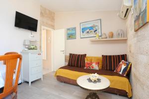een kleine slaapkamer met een bed en een tafel bij Apartments by the sea Rastici, Ciovo - 9717 in Trogir
