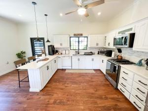a kitchen with white cabinets and a hard wood floor at Westend House Newly Renovated 3 Bedroom in Petit Valley