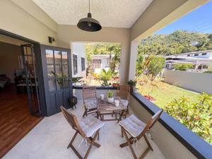 a patio with a table and chairs on a balcony at Westend House Newly Renovated 3 Bedroom in Petit Valley