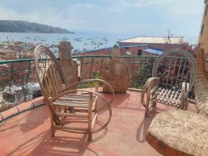two chairs sitting on a balcony overlooking the water at Hostal Leyenda in Copacabana