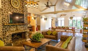 a living room with a fireplace and a tv at Sutera Sanctuary Lodges At Kinabalu Park in Kundasang