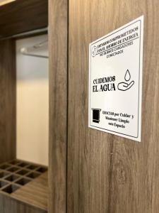 un cartel en una puerta de madera en una habitación en Hotel boutique bussines center, en Cali