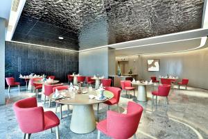 a dining room with tables and red chairs at Yiwu Yandoo Yayue Hotel in Yiwu