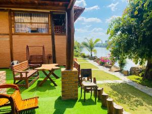a house with a table and chairs on the grass at Floor river view in Cat Tien