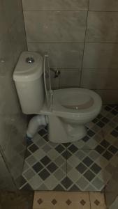 La salle de bains est pourvue de toilettes avec un couvercle. dans l'établissement Lala Elyacout, à Azzaba