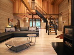a living room with a couch and a staircase at Hygge Chalet Hakuba in Hakuba