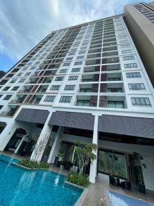 a building with a swimming pool in front of it at Onsen Suits HJM @ Sunway Ipoh in Ipoh