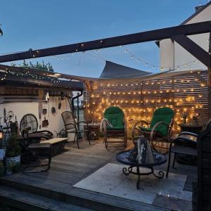 eine Terrasse mit Stühlen, einem Tisch und Lampen in der Unterkunft Retro Haven - A Timeless Escape for Nostalgic Souls by NamastayPL in Marki