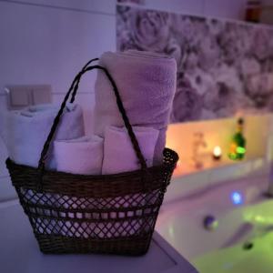einen Korb mit Handtüchern im Bad mit Badewanne in der Unterkunft Retro Haven - A Timeless Escape for Nostalgic Souls by NamastayPL in Marki