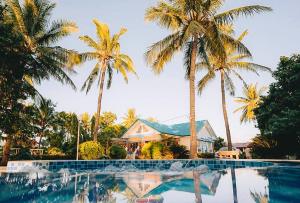 un complejo con palmeras y piscina en RedDoorz @ Balai Baibai Cagayan, en Bawa