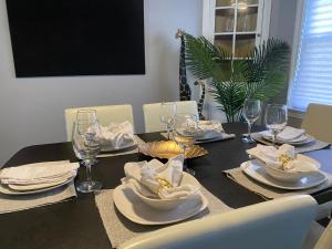 a dining room table with plates and wine glasses at Peace of Cleveland 2bdrm Plus Semi Private Study with Futon 1st Floor Apartment Pets Welcomed, Family Friendly in Cleveland