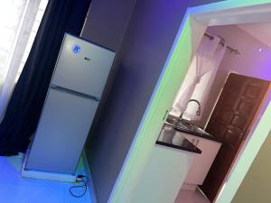a small kitchen with a refrigerator and a rainbow at 3bedroom Joydora apartment in Lusaka