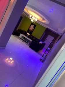 uma sala de estar com iluminação roxa e um sofá em 3bedroom Joydora apartment em Lusaka