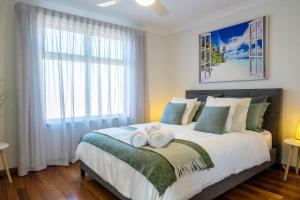 1 dormitorio con 1 cama grande y toallas. en Christies Breeze a luxurious getaway by the sea, en Christies Beach