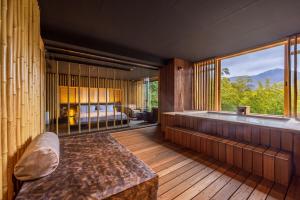 een kamer met een bad, een bed en een raam bij Kinnotake Sengokuhara(Adult Only) in Hakone