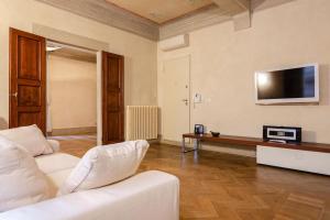Il comprend un salon doté d'un mobilier blanc et d'une télévision à écran plat. dans l'établissement Casa Diamanti, à Bologne