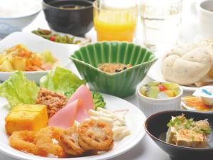 a table with plates of food and bowls of food at Hotel Route Inn Choshi Eki Nishi in Choshi