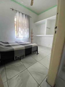 1 dormitorio con 1 cama en una habitación con ventana en Casa térrea a 2 min da praia dos anjos, en Arraial do Cabo