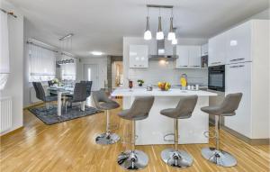 une cuisine et une salle à manger avec un comptoir blanc et des chaises dans l'établissement Gorgeous Home In Varazdin Breg, à Varaždin Breg