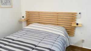 1 cama en un dormitorio con cabecero de madera en Loft en Veracruz en Veracruz