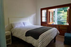 Un dormitorio con una cama grande y una ventana en Gordon Town Kotch, en Kingston