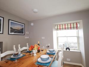 a dining room with a table and chairs and a window at Craggan Cottage - Balmacara in Coillemore