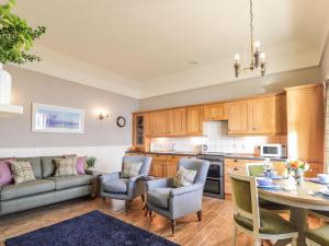 cocina y sala de estar con mesa y sillas en Ferry Cottage - Balmacara en Coillemore
