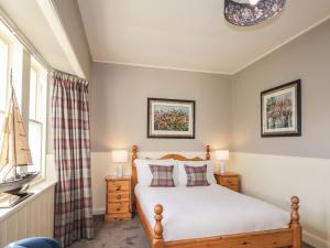 1 dormitorio con cama y ventana en Ferry Cottage - Balmacara en Coillemore
