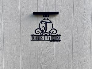 a sign on a white wall with a house nursing house at Torres Tiny Home Midtown WestTampa RJS in Tampa