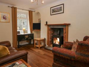 a living room with a fireplace and a couch at Roanview Cottage in Askam in Furness