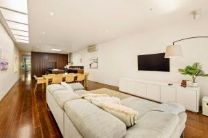 een woonkamer met 2 banken en een televisie bij St Kilda Style - Stunning 3 Bedroom House in Melbourne