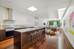 a kitchen with a large island with bar stools at St Kilda Style - Stunning 3 Bedroom House in Melbourne