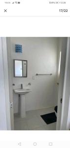 ein weißes Badezimmer mit einem Waschbecken und einem Spiegel in der Unterkunft Loft 202 in Acapulco
