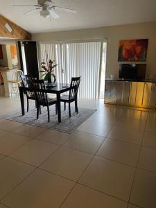 uma sala de jantar com uma mesa e cadeiras num piso de azulejo em Cozy Guest House Florida, 5801 em Sunrise