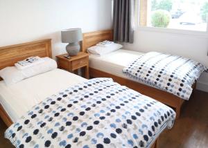 2 camas individuales en una habitación con ventana en North Shore Holiday Park, en Winthorpe