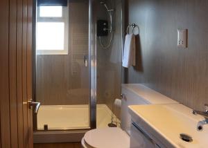 a bathroom with a shower and a toilet and a sink at North Shore Holiday Park in Winthorpe