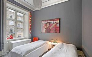 コペンハーゲンにあるCopenhagen Apartment with excellent locationのベッドルーム1室(ベッド2台付)、壁にポスターが備わります。