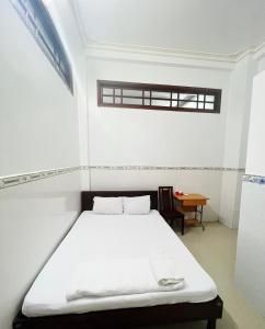 Camera bianca con letto e tavolo di Thanh Tâm Hotel a Ấp Bình Phó