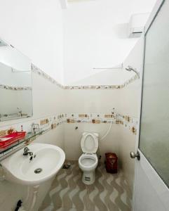 bagno bianco con lavandino e servizi igienici di Thanh Tâm Hotel a Ấp Bình Phó