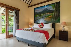 a bedroom with a bed with a large painting on the wall at Alamanda Lovina Resort in Lovina