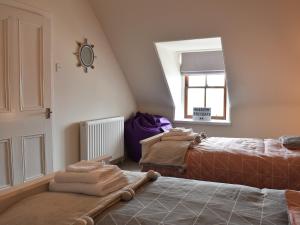 A bed or beds in a room at Acarsaid Cottage