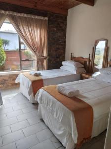 three beds in a room with a window at Hamba Kancane Ma-Africa Guest House in Graskop