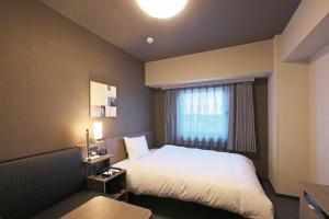 Habitación de hotel con cama y ventana en Hotel Route Inn Kyoto Maizuru -Nishi Maizuru Ekimae-, en Maizuru