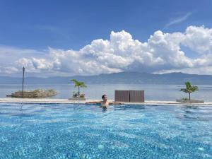 a person in a swimming pool near the water at Mas Cottages in Tuk Tuk