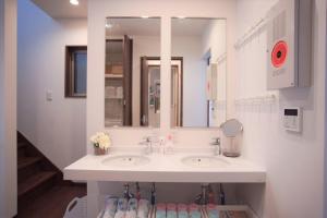 a white bathroom with a sink and a mirror at Kaika Inn in Osaka
