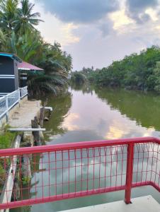 un fiume con un ponte rosso accanto a una casa di Airport Kota Bharu Transit Inn a Kota Bharu