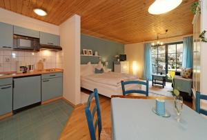 a kitchen and a bedroom with a bed and a table at Herzigs Ferienhaus Mitterdorf in Mitterfirmiansreut